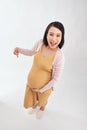 Asian pregnant woman feeling happy pointing finger on her belly on white background