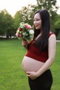 Asian pregnant woman hold Bouquet smell fragrance of flower  in garden forest lawn outdoor nature free relax happy sunshine Royalty Free Stock Photo