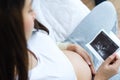 Asian pregnant woman holding ultrasound film scan of baby Royalty Free Stock Photo