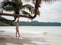 Asian pregnant woman posture on tropical sand beach with palm tree in sunny day in Thailand. Pregnancy relaxation from depression Royalty Free Stock Photo