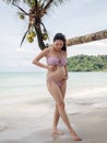Asian pregnant woman posture on tropical sand beach with palm tree in sunny day in Thailand. Pregnancy relaxation from depression Royalty Free Stock Photo