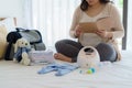 Asian Pregnant woman prenatal calendar planner and baby monitor utensils, container preparation for pregnancy concept
