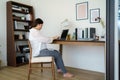 Asian pregnant woman  using a laptop while working on maternity leave at her living room table at home Royalty Free Stock Photo