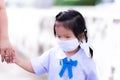 Asian preschool child girl wearing a protective face mask. Kid wearing school uniform walking and she hold hand in hand mother. Royalty Free Stock Photo