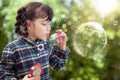 Asian preschool girl play soap bubble by blowing toy in playsgound Royalty Free Stock Photo