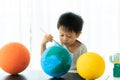 Asian preschool student boy painting the moon learning about the solar system at home, Homeschooling and distance learning