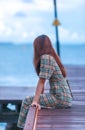 Asian pretty gilr wearing dress so alone feeling with walking and sit on walk way to to sea on evening Royalty Free Stock Photo