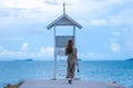 Asian pretty gilr wearing dress so alone feeling with walking and sit on walk way to to sea on evening Royalty Free Stock Photo