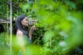 Asian pretty girl has relaxing with happy and smiling at Little Tree Garden cafe, Nakhon Pathom province, Thailand in the morning Royalty Free Stock Photo