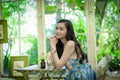 Asian pretty girl has relaxing with happy and smiling at Little Tree Garden cafe, Nakhon Pathom province, Thailand in the morning Royalty Free Stock Photo