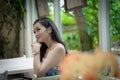 Asian pretty girl has relaxing with happy and smiling at Little Tree Garden cafe, Nakhon Pathom province, Thailand in the morning Royalty Free Stock Photo
