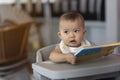 Asian pretty lovely baby girl with her colorul reading book and smile laughing action