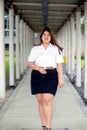 Asian pretty smiley face fat woman pose in student uniform on wa walkway.