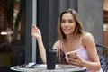 asian pretty woman sits outdoors, writes notes in notebook, holds smartphone Royalty Free Stock Photo