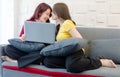 Asian pretty young female lesbian lover sitting smiling on cozy sofa with couple partner using laptop computer browsing surfing Royalty Free Stock Photo