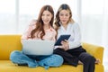 Asian pride proud female lesbian LGBTQ lover couple with headphone sitting smiling on cozy sofa surfing browsing internet shopping Royalty Free Stock Photo