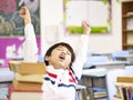 Asian primary school student stretching in classroom Royalty Free Stock Photo