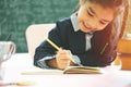 Asian primary school student studying homework in classroom. Royalty Free Stock Photo