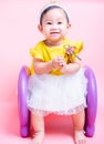 Asian princess little baby girl sitting on chair she is smile in studio on pink