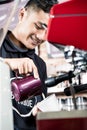 Asian professional barista making espresso