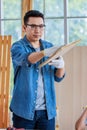 Asian professional male carpenter woodworker engineer in jeans outfit with safety gloves and goggles using measuring ruler pencil Royalty Free Stock Photo