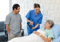 Asian professional successful female assistant internship nurse in blue uniform holding tablet computer visiting discussing