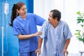 Asian professional successful female internship nurse in blue uniform smiling visiting helping supporting old senior elderly