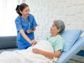 Asian professional successful female internship nurse in blue uniform with stethoscope visiting old senior elderly pensioner woman Royalty Free Stock Photo