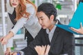 Asian professional successful male businessman in formal suit sitting working using laptop computer while two female businesswomen Royalty Free Stock Photo