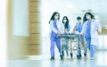 Asian professional teamwork doctors, nurses in surgical gown and white coat uniform running with hurry, taking emergency patient