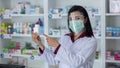 Asian Professional women pharmacist with protective face shield on his face working in modern drugstore and showing white medicine Royalty Free Stock Photo