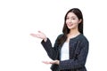 Asian professional working woman who wears black suit with braces on teeth is pointing hand to present something smiling standing Royalty Free Stock Photo