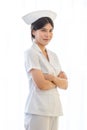 Asian professional young cheerful female nurse in white uniform standing smiling crossed arms posing on white background Royalty Free Stock Photo