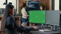 Asian programer writing code in front of computer with green screen chroma key mockup
