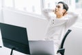 Asian programmer sits with his head back in his chair to relax after a tiring working time