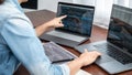 Asian programmer woman pointing and looking on multiple laptop screen to writing code and database