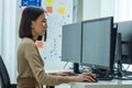 Asian prompt engineer develop coding app with software data sitting in front of computer monitor at office