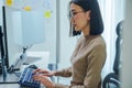 Asian prompt engineer develop coding app with software data sitting in front of computer monitor at office