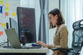Asian prompt engineer develop coding app with software data sitting in front of computer monitor at office