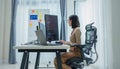 Asian prompt engineer develop coding app with software data sitting in front of computer monitor at office