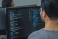 Asian prompt engineer developer coding app with software data sitting in front of computer monitor at office