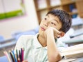 Asian pupil daydreaming in classroom Royalty Free Stock Photo