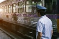 Asian Railway police looking outside at railroad tracks.