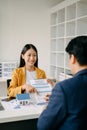 Asian Real estate broker agent presenting and consult to customer to decision making sign insurance form agreement, home model, Royalty Free Stock Photo