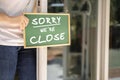 Asian restaurant owners are hanging a blackboard with the word closed