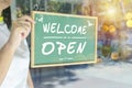 Asian restaurant owners are hanging a blackboard with the word welcome open to open the shop