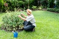 Asian retired man Spend free time doing activities By taking care of the flower garden Royalty Free Stock Photo