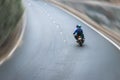 Asian riding a motorbike on an empty road