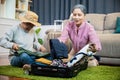 Asian romantic retired couple packing clothes travel bag suitcase together on floor at home Royalty Free Stock Photo