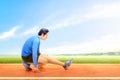 Asian runner man stretching legs before starting the run on the running track Royalty Free Stock Photo